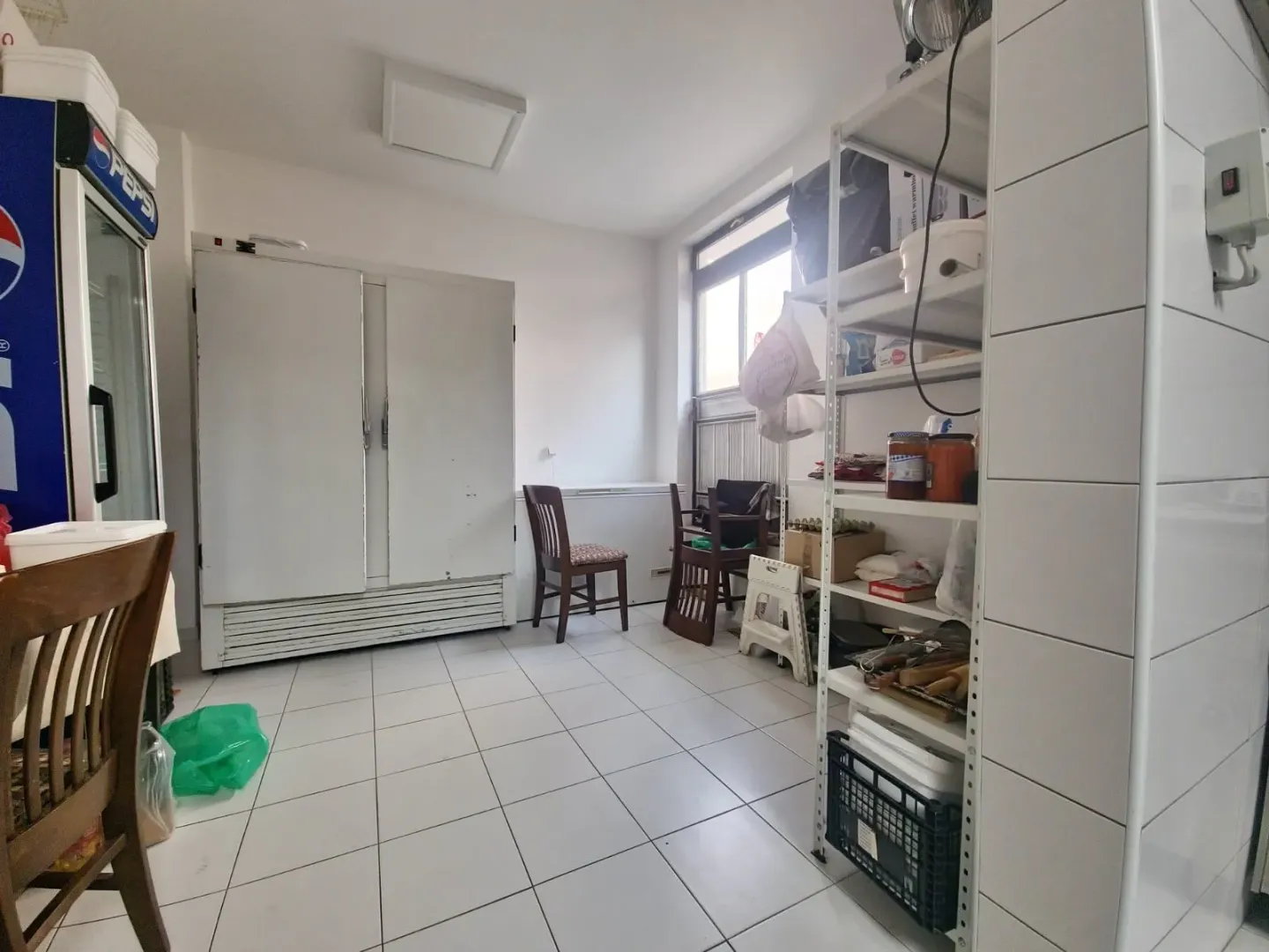 Utility room or kitchen equipped with shelving units and refrigeration appliances.