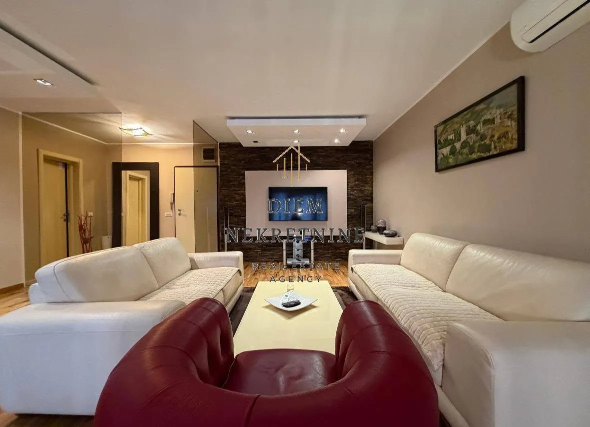 Furnished living room with sofa set and TV.