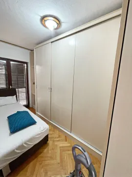 Bedroom featuring a large built-in wardrobe and parquet flooring. - image 9