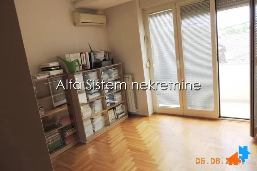 Room with wooden flooring, shelving units, and access to the terrace.