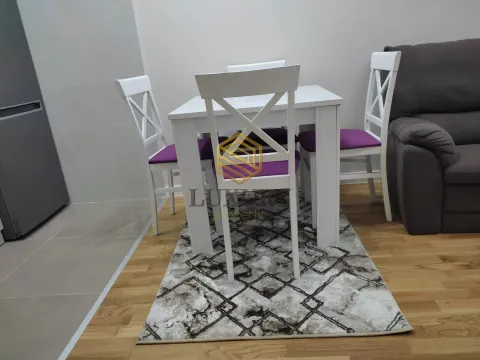 Trpezarijski sto sa bijelim stolicama i ljubičastim jastucima u dnevnom boravku. - image 6