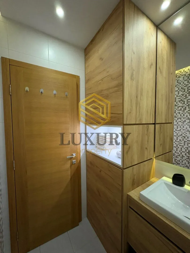 Modern bathroom with wooden elements and a built-in sink.