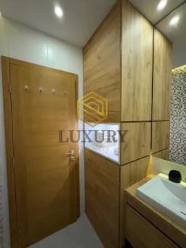 Modern bathroom with wooden elements and a built-in sink. - image 2