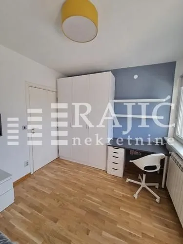 Furnished bedroom with a desk and wardrobe.