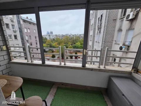 Zastakljeni balkon sa pogledom na okolne zgrade i zelenilo. - image 15