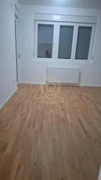 Prazna soba sa parketom i belim zidovima. - image 2