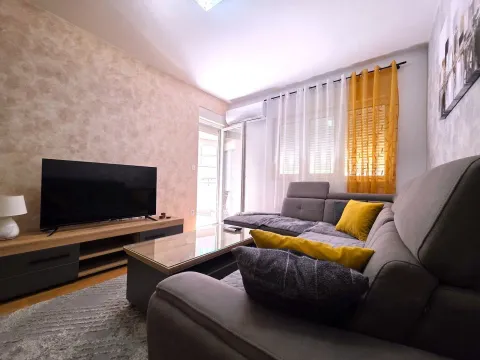 Living room with a corner sofa, television, and access to the terrace. - image 2