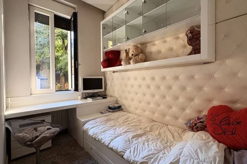 Children's bedroom with a bed, desk, and wall-mounted cabinet.