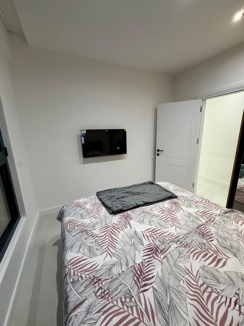 Bedroom with a double bed and a wall-mounted TV.