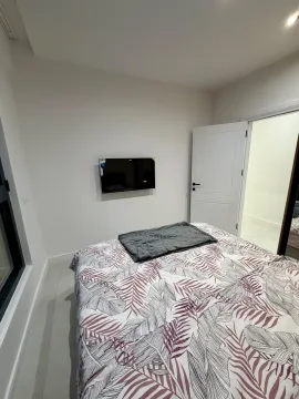 Bedroom with a double bed and a wall-mounted TV. - image 5
