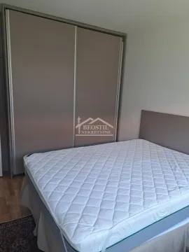 Nameštena spavaća soba sa bračnim krevetom i velikim ormanom. - image 6
