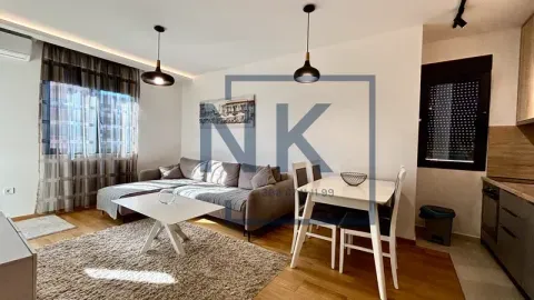 Living room with a sofa, dining table, and part of the kitchen. - image 4