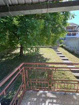 Pogled sa terase na zeleno dvorište i okolne kuće. - image 2