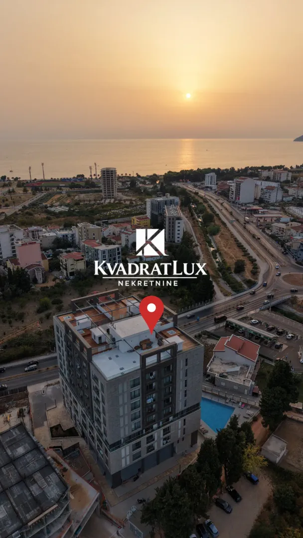 Pogled iz vazduha na grad sa pogledom na more i zalazak sunca.