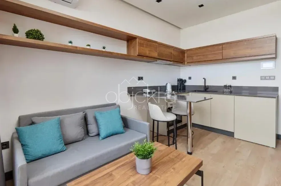 Small kitchen with a bar counter and dining table, connected to the living room.