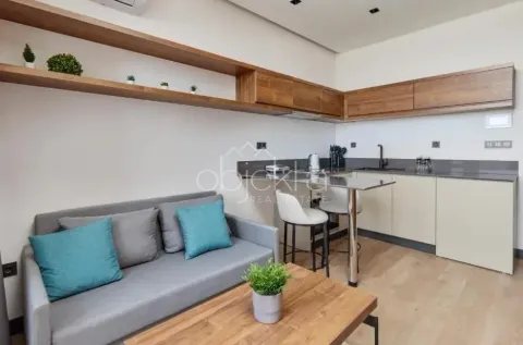 Small kitchen with a bar counter and dining table, connected to the living room. - image 6