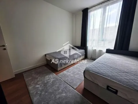 Bedroom with two single beds and a large window. - image 10