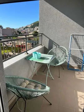 Furnished balcony with a table, chairs, and city view. - image 8