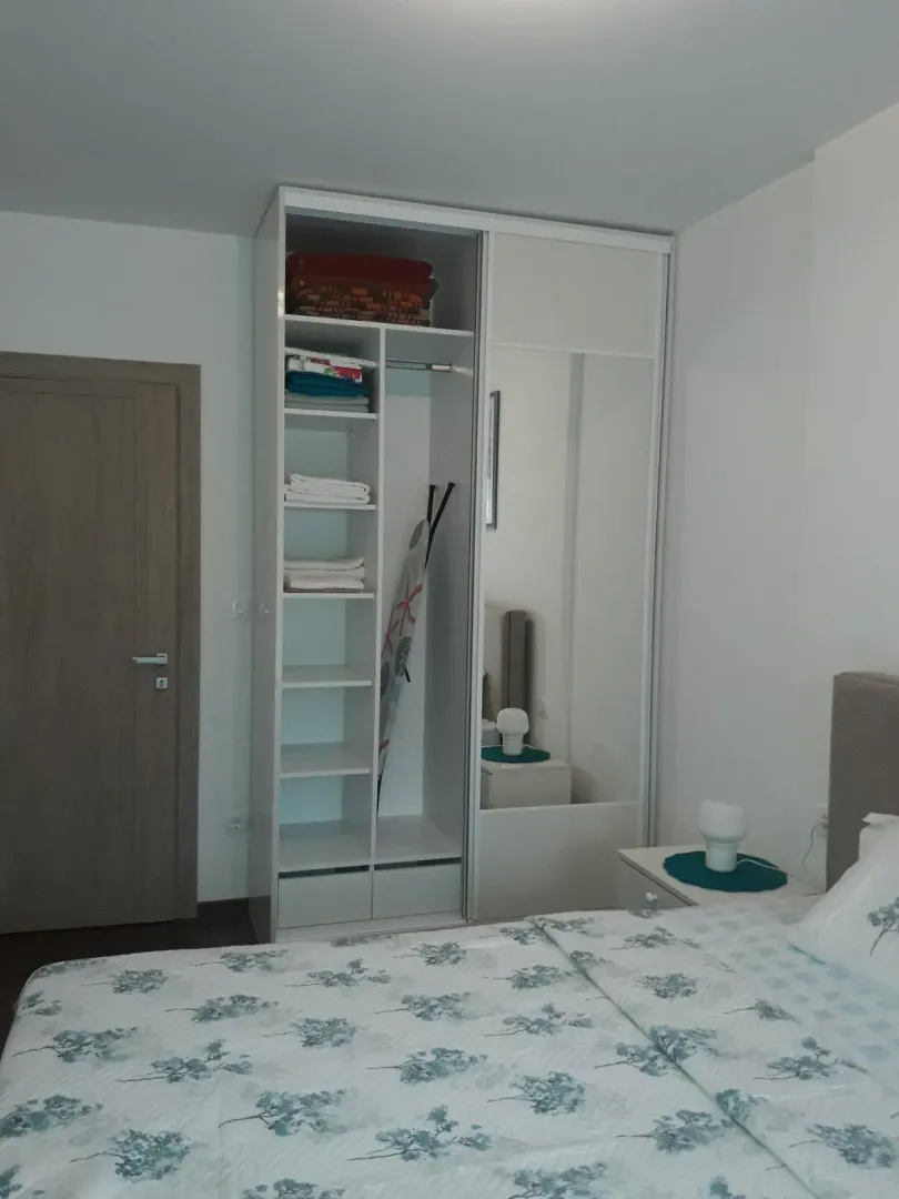 Bright bedroom with a large wardrobe and a bed.