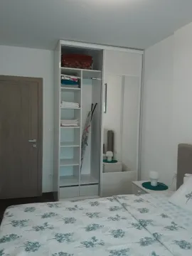 Bright bedroom with a large wardrobe and a bed. - image 9