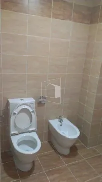 Small bathroom with ceramic tiles, toilet, and bidet. - image 8