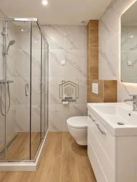 Moderno opremljeno kupatilo sa tuš kabinom, umivaonikom i WC šoljom. - image 2