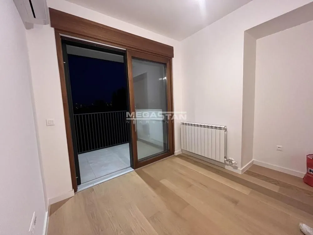Empty room with wooden flooring and access to the terrace.