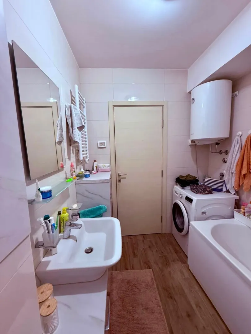 Fully equipped bathroom with a bathtub, washbasin, and washing machine.