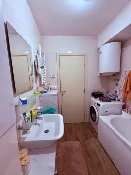 Fully equipped bathroom with a bathtub, washbasin, and washing machine. - image 10
