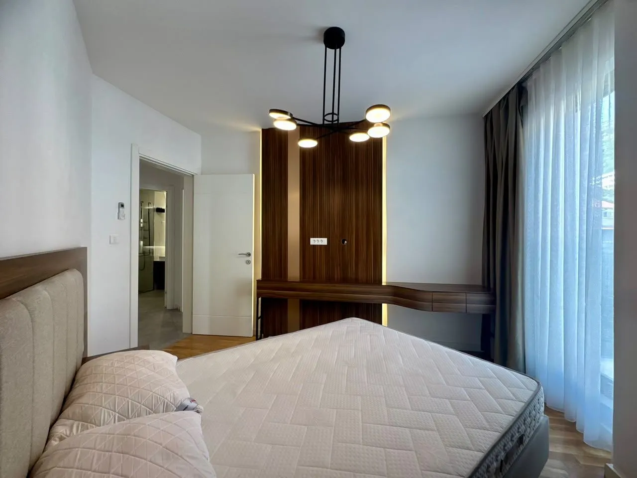 Modern bedroom with a double bed and built-in furniture.