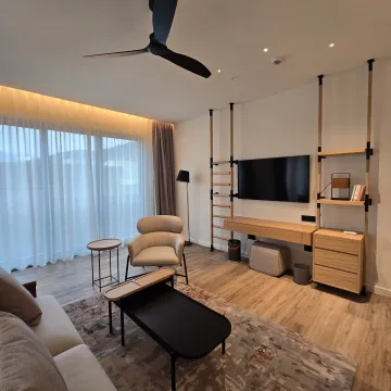 Moderno opremljena dnevna soba sa garniturom, TV-om i plafonskim ventilatorom. - image 3