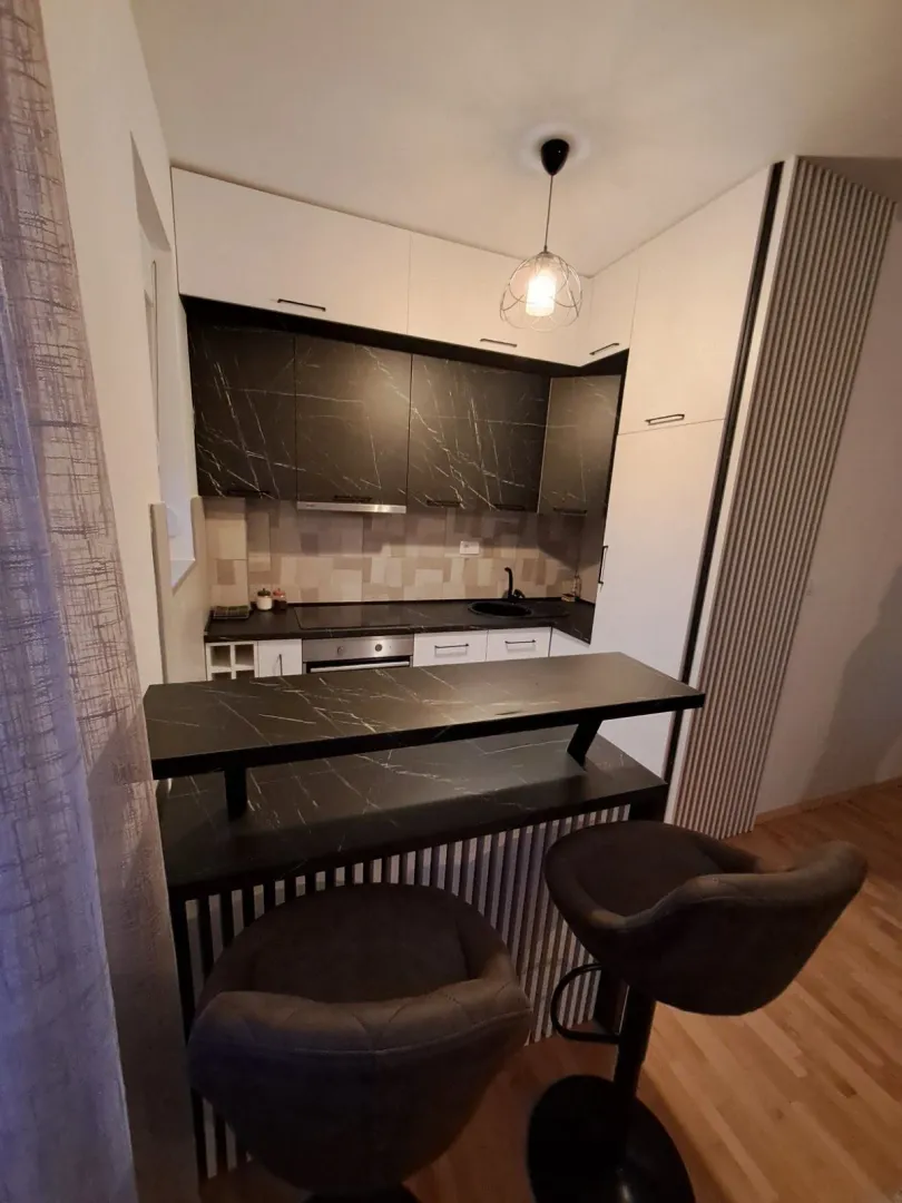 A modern kitchen with a bar counter and bar stools.