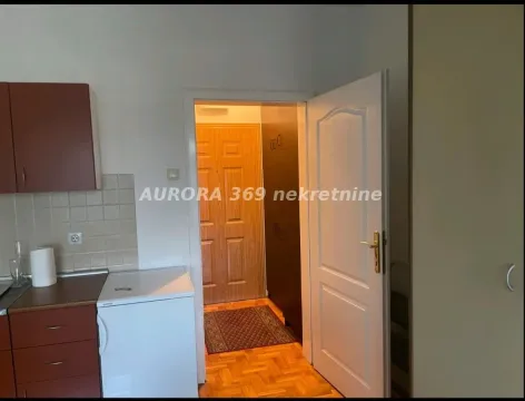 Pogled iz kuhinje na hodnik sa drvenim vratima i parketom. - image 3