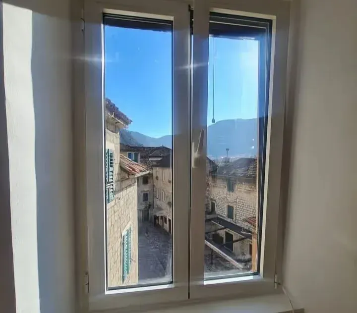 View through the window overlooking the old town street and surrounding mountains.