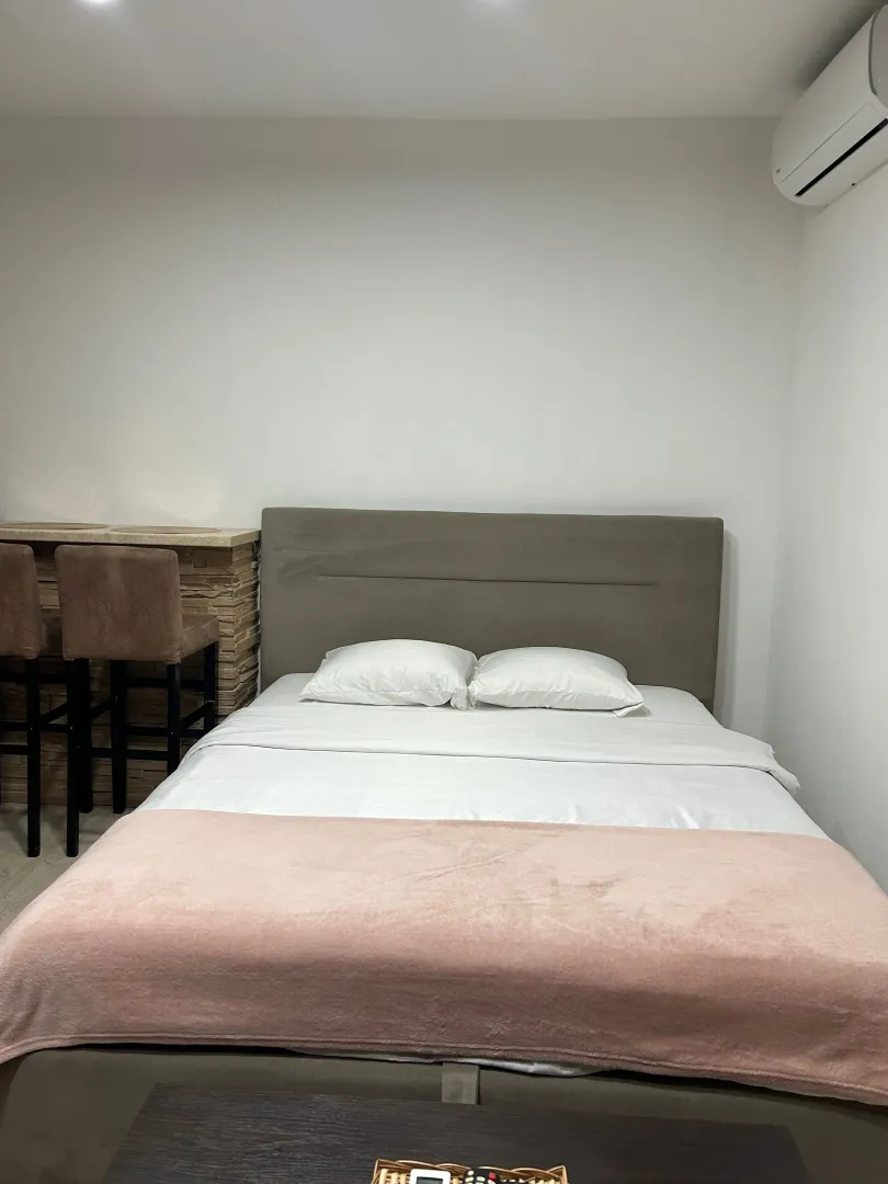 Spavaća soba sa bračnim krevetom i klima uređajem.