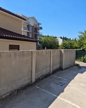 Pogled na spoljašnji dio zgrade sa parkingom i betonskim zidom. - image 11