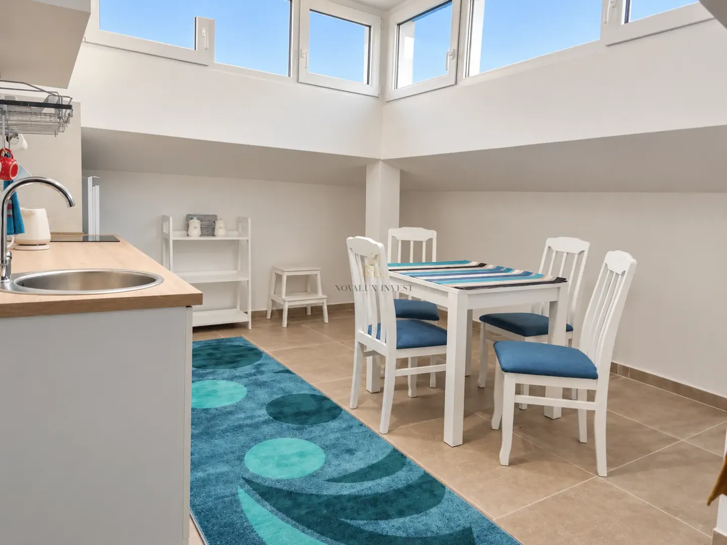 Small kitchen with a dining table and chairs under a sloped ceiling.