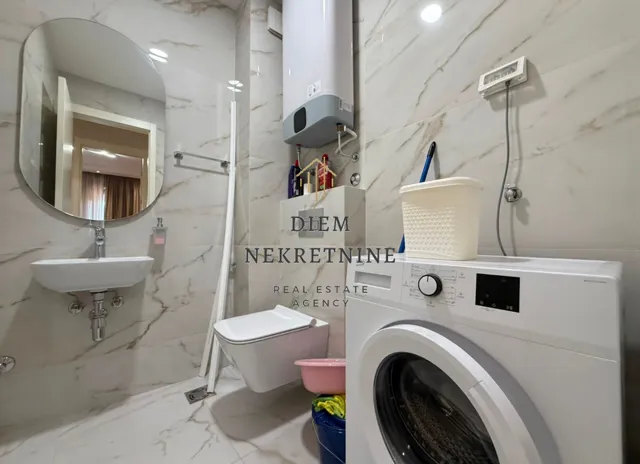 Modernly equipped bathroom with a washing machine.