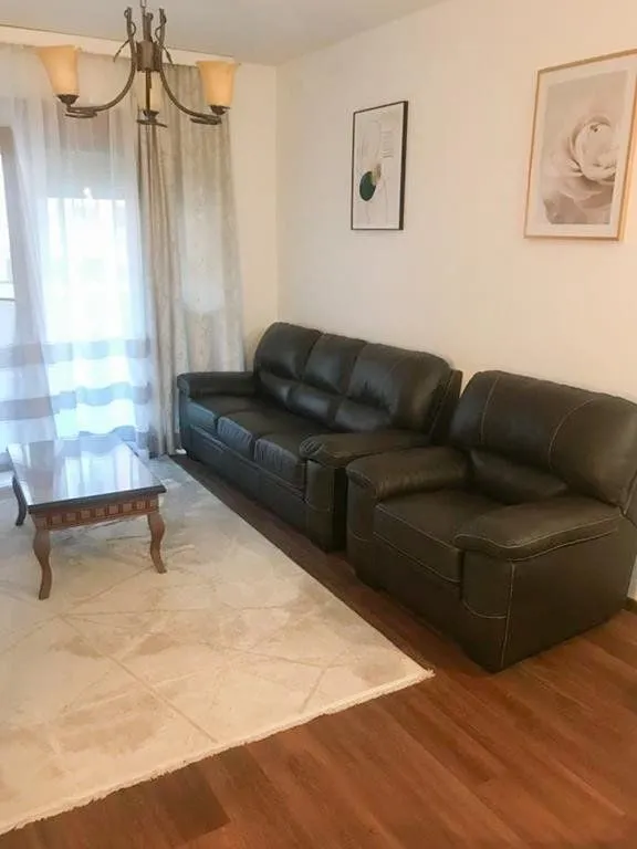 Dnevna soba sa garniturom za sjedenje, stočićem i lusterom.