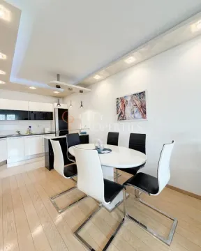 Dining area with a table and chairs and a view of the kitchen. - image 2