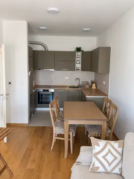 Modern kitchen with a dining table and chairs as part of the living area. - image 2