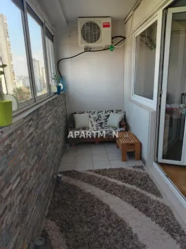 Enclosed balcony with a bench, small table, and rug. - image 9