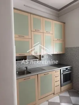 Manja kuhinja sa drvenim elementima u bež i zelenoj boji i ugradnim aparatima. - image 6