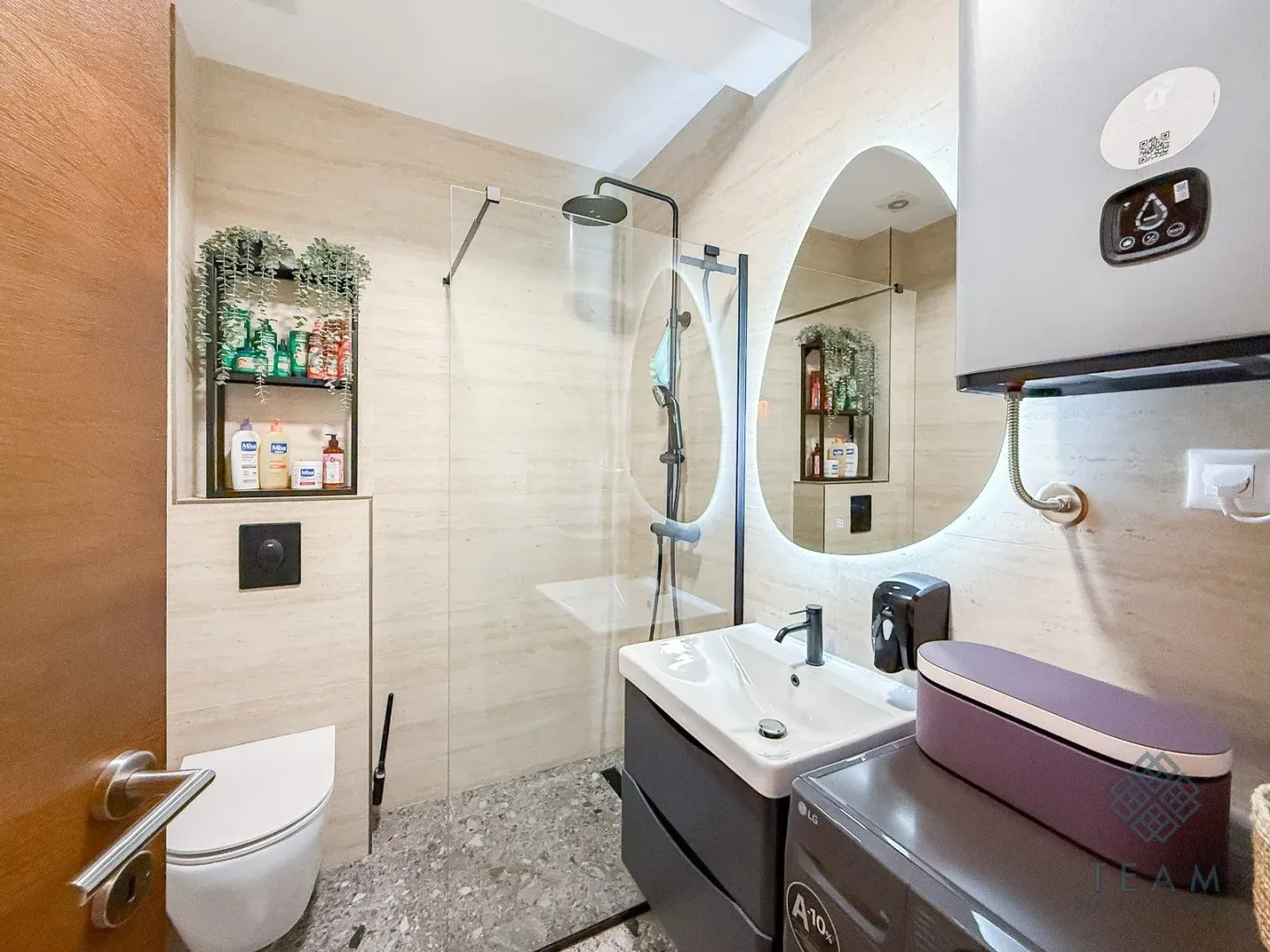 Modernly equipped bathroom with a walk-in shower, washbasin, and toilet.
