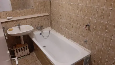 Kupatilo obloženo keramičkim pločicama sa kadom i umivaonikom. - image 14