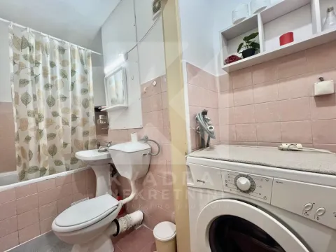 Bathroom with a bathtub, sink, toilet, and washing machine. - image 9