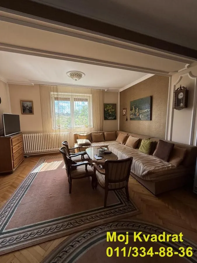 Dnevna soba sa garniturom za sedenje, klub stočićem i televizorom.