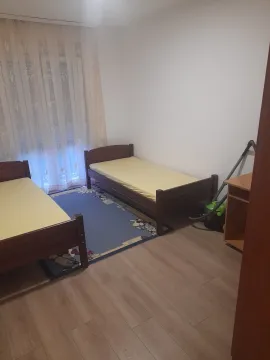 Spavaća soba sa dva singl kreveta i plavim tepihom. - image 7