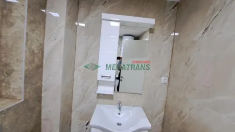 Kupatilo obloženo keramičkim pločicama sa umivaonikom i ogledalom. - image 8