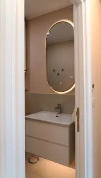 Pogled kroz otvorena vrata na kupatilo sa umivaonikom i ogledalom. - image 13